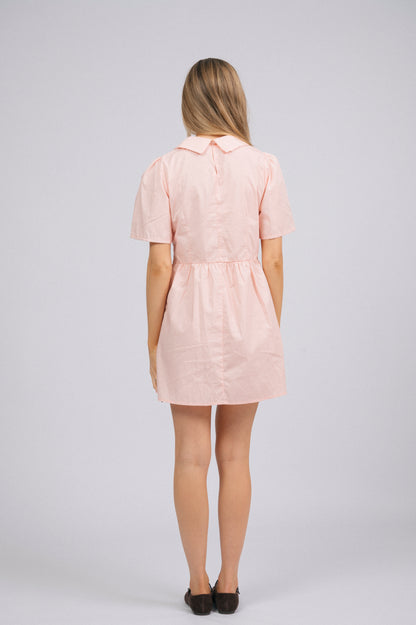 Vintage cottage core baby pink babydoll mini dress with peter pan collar, midi-length sleeves, front white buttons, and pockets back view - Lemon Lane Vintage