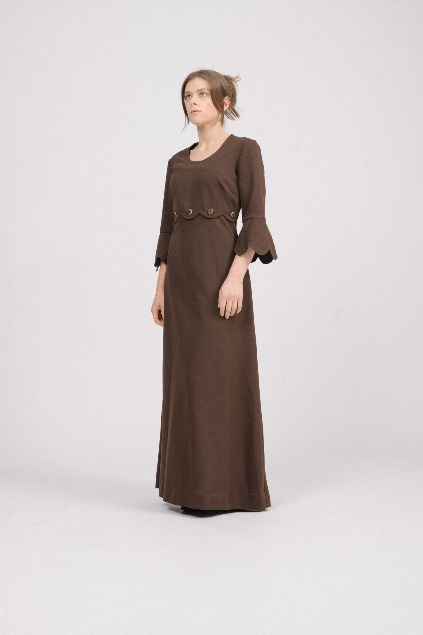 Model wearing 1970s brown vintage maxi dress in feminine cottagecore style.
