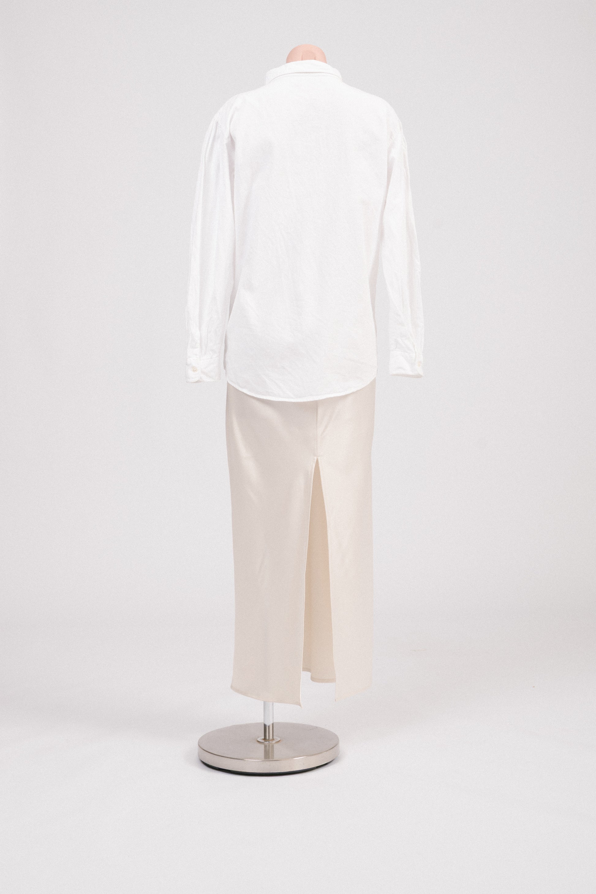 Back view of vintage white embroidered cotton blouse showing shoulder gathering and long sleeves.