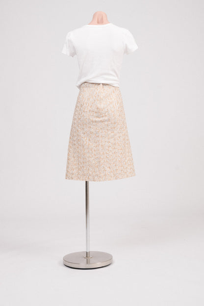 Back view of vintage beige midi skirt showing straight silhouette, fully lined, and delicate floral embroidery with small cut-outs. Heirloom-inspired vintage clothing Australia.
