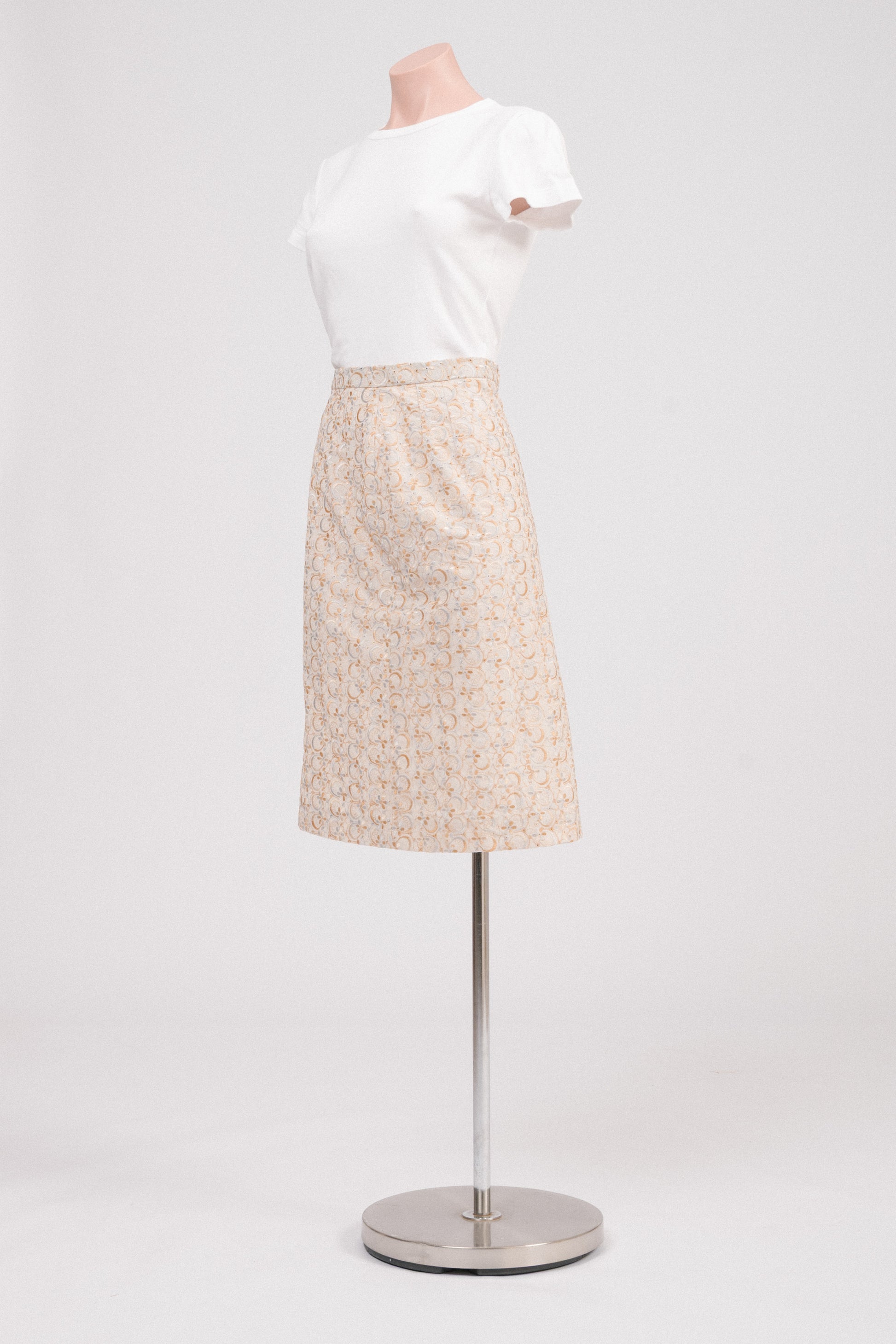 Side view of vintage midi skirt with floral embroidery and structured fit.