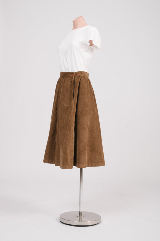 Side view of vintage brown corduroy A-line skirt featuring side button fastening and soft A-line drape.