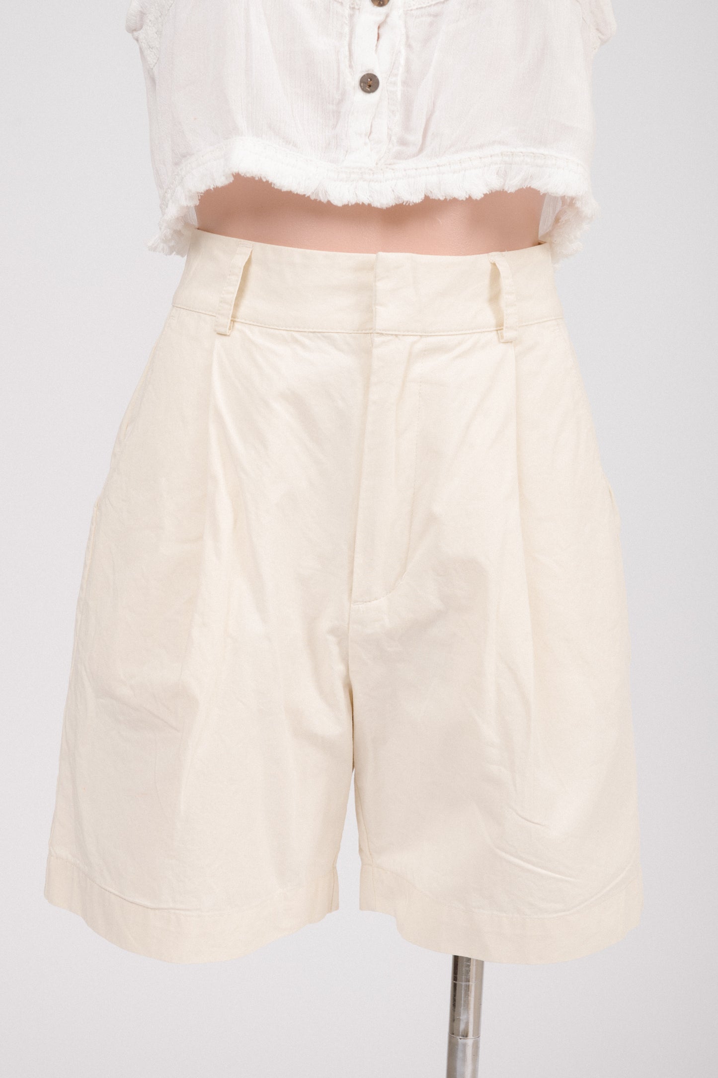 Close-up of lapped fly with hook-and-bar closure and metal zipper on buttercream shorts.