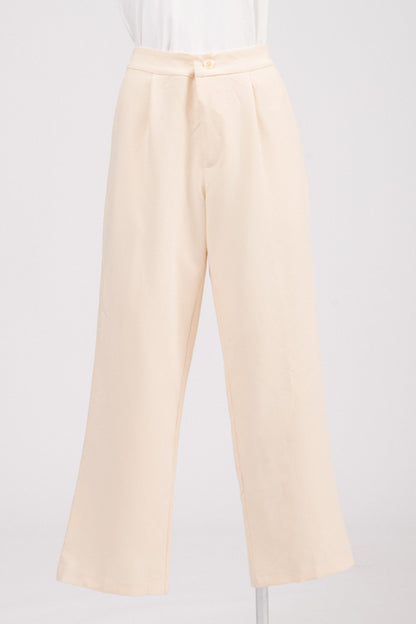 Close-up of textured fabric and pearl-style button on tailored pants.