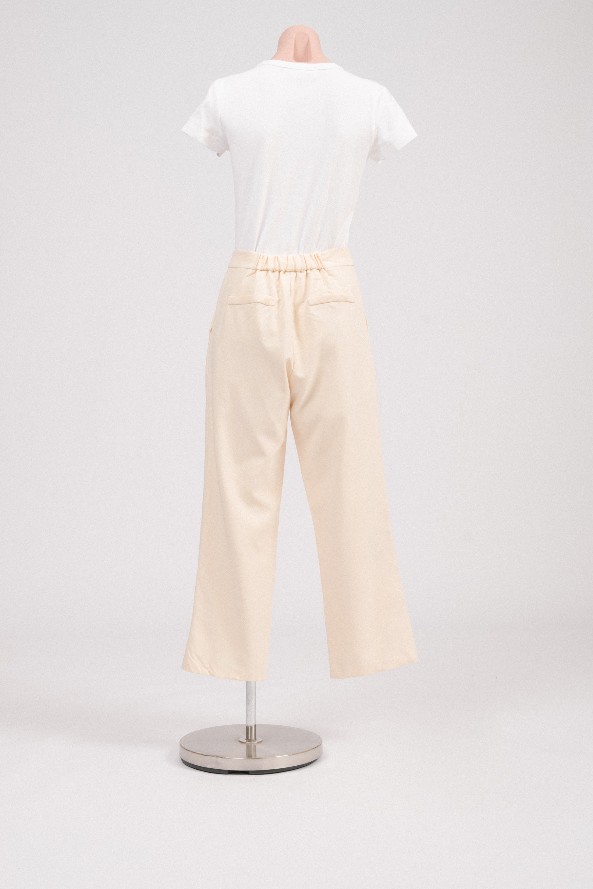 Back view of buttercream pants with elasticated waist and faux welt pockets.