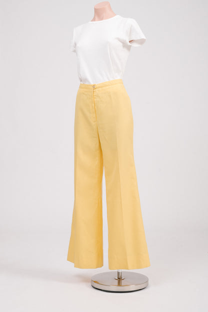Side profile of vintage 70s yellow flare pants, highlighting structured fit and flared leg silhouette, perfect retro tailored trousers for feminine wardrobe.