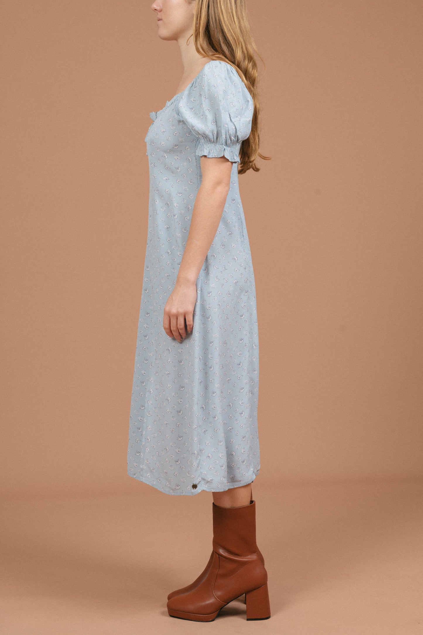 Vintage blue floral midi dress with puffy cap sleeves, ruffle detailing, and front bow side view - Lemon Lane Vintage
