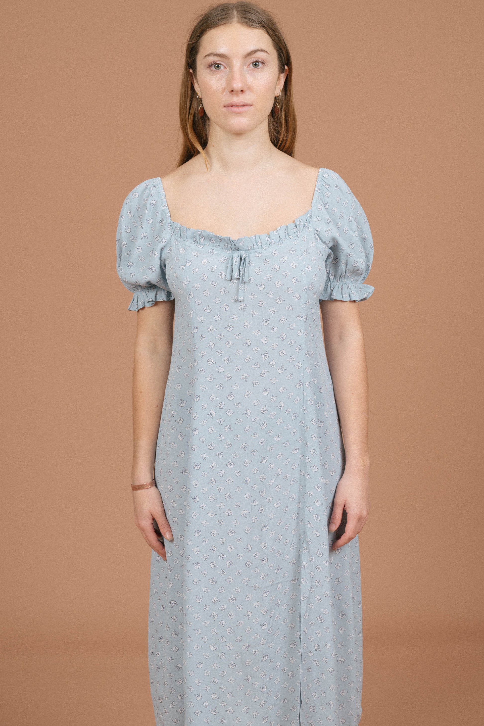 Vintage blue floral midi dress with puffy cap sleeves, ruffle detailing, and front bow front view - Lemon Lane Vintage