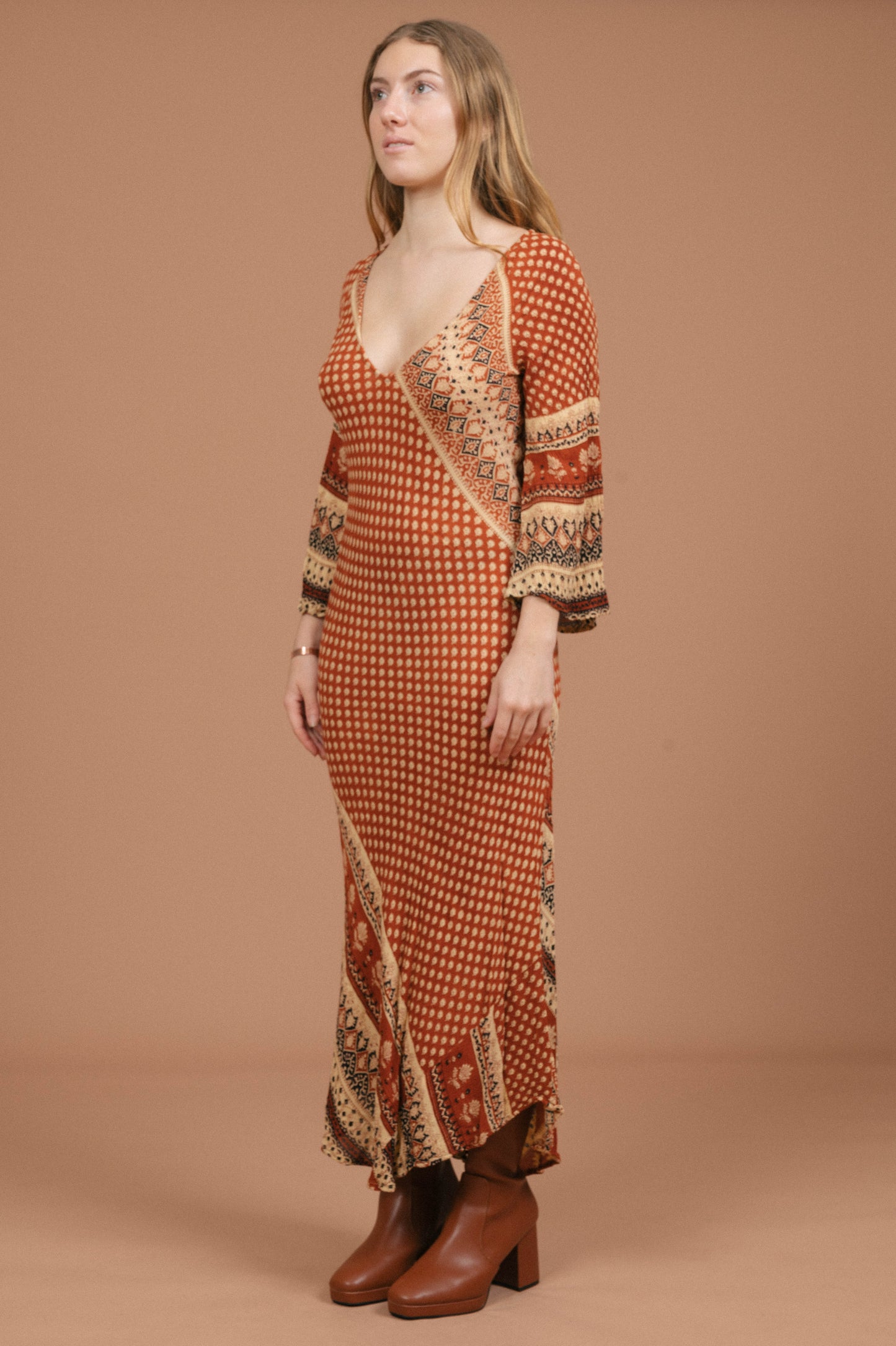 Vintage long bell sleeved slip maxi dress in rust and multi-coloured fabric side view - Lemon Lane Vintage