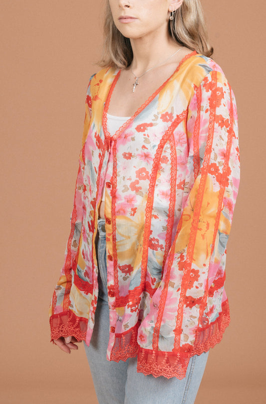 Vintage sheer floral blouse in pink and orange with lace detailing, long sleeves, and button-up side view - Lemon Lane Vintage