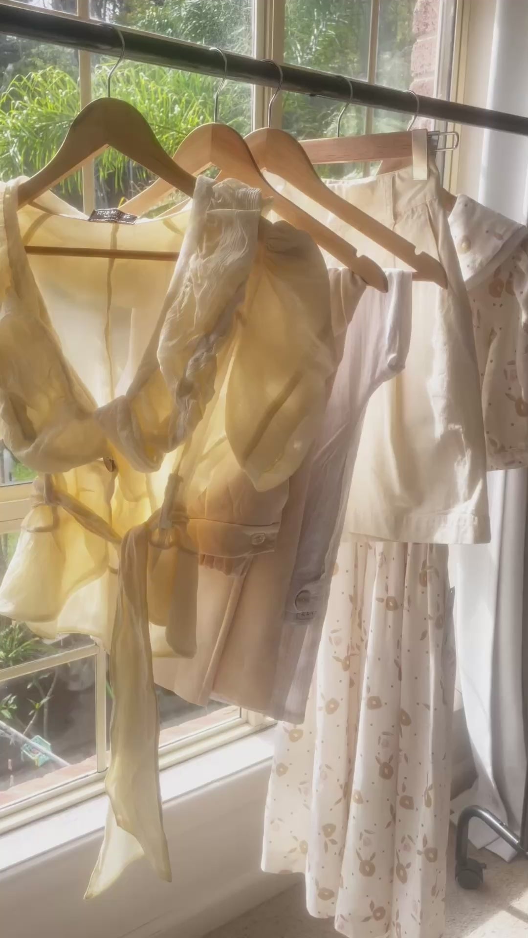 Load video: Women&#39;s vintage clothing Australia. Vintage Summer Collection video featuring yellow and neutral toned dresses, blouses and tailored pants blowing in the sun on a clothing rack. Feminine cottagecore style by Lemon Lane Vintage.